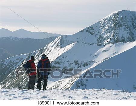 Stock Image - Couple On Top Of Aonach Mor With Ben Nevis Behind. Fotosearch