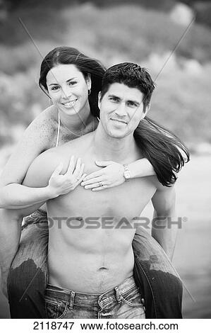 Stock Photo - Couple Piggybacking On A Beach; Encinitas California Usa. Fotosearch