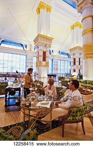 Stock Photography - Couple relaxing at The Empire Hotel and Country Club; Bandar Seri Begawan, Brunei. Fotosearch