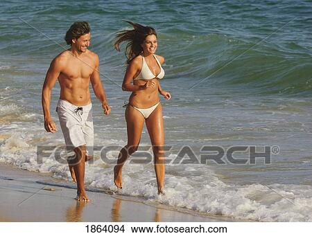 Couple Running Along The Beach View Large Photo Image Picture - Couple Running Along The Beach. Fotosearch