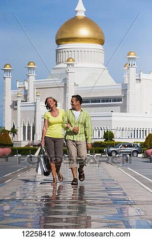 Couple shopping with Sultan Omar Ali Saifuddien Mosque in the background; Bandar Seri Begawan, Brunei View Large Photo Image Stock Image - Couple shopping with Sultan Omar Ali Saifuddien Mosque in the background; Bandar Seri Begawan, Brunei. Fotosearch