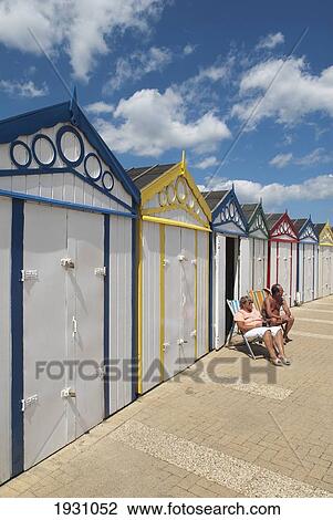 Couple sitting in front of beach huts on the promenade, Great Yarmouth, Norfolk, England, United Kingdom, Great Yarmouth, Norfolk, England, United Kingdom. View Large Photo Image Stock Image - Couple sitting in front of beach huts on the promenade, Great Yarmouth, Norfolk, England, United Kingdom, Great Yarmouth, Norfolk, England, United Kingdom.. Fotosearch