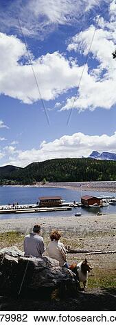 Couple Sitting On Rock With Collie Admiring Lake Minnewanka View Large Photo Image Stock Image - Couple Sitting On Rock With Collie Admiring Lake Minnewanka. Fotosearch