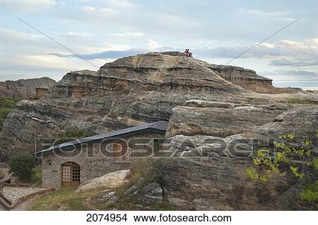 Couple Sitting On The Eroded Jurassic Sandstone Massif Near The Relais De La Reine In Isalo National Park, Fianarantsoa Province, Madagascar View Large Photo Image Picture - Couple Sitting On The Eroded Jurassic Sandstone Massif Near The Relais De La Reine In Isalo National Park, Fianarantsoa Province, Madagascar. Fotosearch