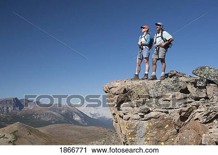 Stock Image - Couple Standing On The Top Of A Mountain; Jasper National Park, Alberta, Canada. Fotosearch