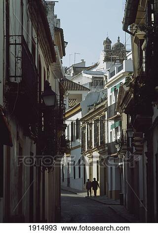 Stock Image - Couple Walking Down Alley In Cordoba. Fotosearch