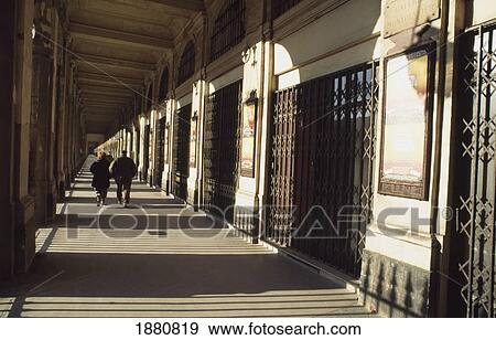 Stock Photo - Couple Walking Down Hallway At Place Du Palais Royal. Fotosearch