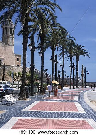 Stock Photograph - Couple Walking Down Promenade Beside Sea. Fotosearch
