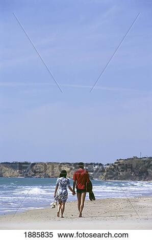 Couple Walking Hand In Hand Down The Beach View Large Photo Image Stock Photography - Couple Walking Hand In Hand Down The Beach. Fotosearch