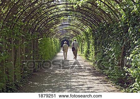 Stock Image - Couple Walking In Mirabell Gardens. Fotosearch
