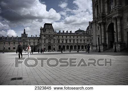 Stock Photography - Couple walking in the Louvre Museum's courtyard; Paris, France. Fotosearch