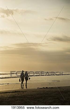 Couple Walking On Beach At Sunset View Large Photo Image Stock Photography - Couple Walking On Beach At Sunset. Fotosearch