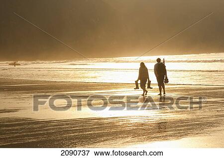 Couple Walking On The Beach At Sunset In Putsborough Sands, North Devon, Uk View Large Photo Image Stock Photo - Couple Walking On The Beach At Sunset In Putsborough Sands, North Devon, Uk. Fotosearch