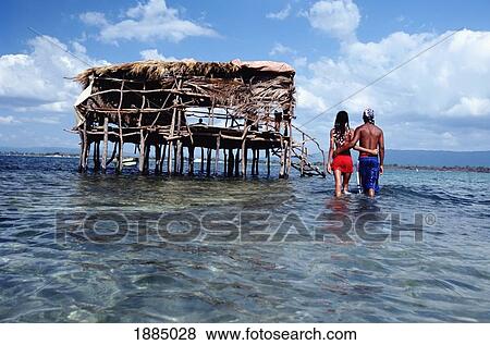 Stock Photo - Couple Walking Towards Pelican Bar. Fotosearch