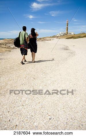 Picture - Couple Walking Towards The Lighthouse In Cabo Polonio, Uruguay, South America. Fotosearch