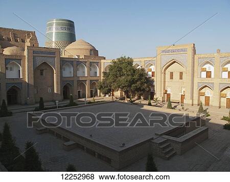 Stock Photo - Courtyard of Hotel Khiva (formerly Mohammed Amin Khan madrassah) and Kalta Minar behind, Ichan Kala Old City; Khiva, Uzbekistan. Fotosearch