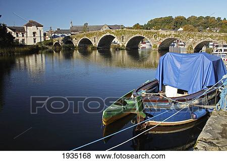 Stock Photo - Covered Boat And Stone Bridge Over River Barrow; Graiguenamanagh, County Kilkenny, Ireland. Fotosearch