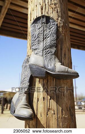 Stock Image - Cowboy Boots Hanging From A Post At A Riding Ranch; Arizona Usa. Fotosearch