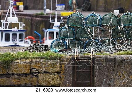 Stock Image - Crab Traps Piled On The Shore At The Harbour; Burnmouth Scottish Borders Scotland. Fotosearch