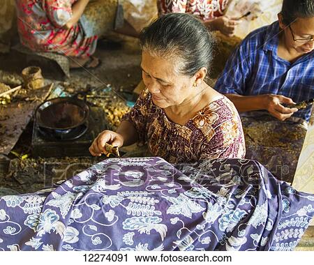 Craftswomen drawing intricate patterns by using a pen-like instrument, called canting, to apply hot wax to a fabric in the production of batik at Sarwidi's Batik workshop, Banyuripan-Bayat, Central Java, Indonesia View Large Photo Image Stock Image - Craftswomen drawing intricate patterns by using a pen-like instrument, called canting, to apply hot wax to a fabric in the production of batik at Sarwidi's Batik workshop, Banyuripan-Bayat, Central Java, Indonesia. Fotosearch