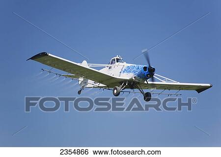 Crop Dusting Plane In A Blue Sky; Crossfield, Alberta, Canada View Large Photo Image Stock Photograph - Crop Dusting Plane In A Blue Sky; Crossfield, Alberta, Canada. Fotosearch