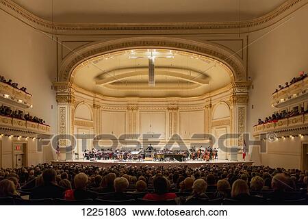 Stock Image - Crowd enjoying orchestra performance in Carnegie Hall; New York City, New York, United States of America. Fotosearch