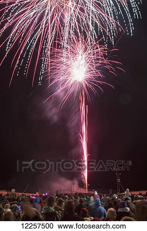 Stock Image - Crowd watching fireworks display; South Shields, Tyne and Wear, England. Fotosearch