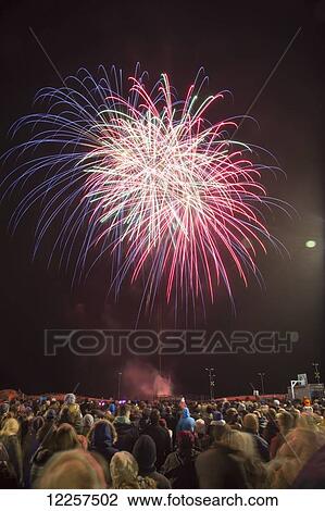 Stock Image - Crowd watching fireworks display; South Shields, Tyne and Wear, England. Fotosearch