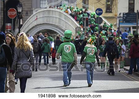 Stock Photo - Crowds Of People Walking Down The Street Many Wearing Green Celebrating Saint Patrick's Day; County Dublin Ireland. Fotosearch