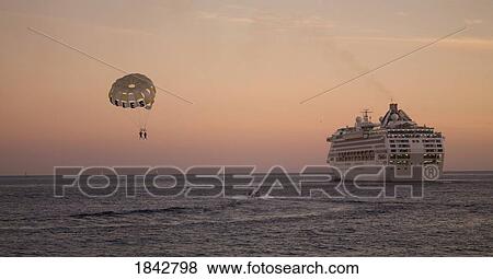 Cruise Ship And Two People With Paraschute Above Sea, Dusk; Los Cabos, Mexico View Large Photo Image Stock Photo - Cruise Ship And Two People With Paraschute Above Sea, Dusk; Los Cabos, Mexico. Fotosearch
