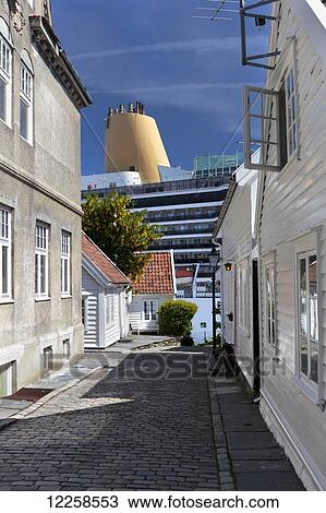 Stock Image - Cruise ship docked at Stavanger, viewed down narrow side street; Stavanger, Norway. Fotosearch