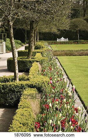 Stock Photography - Cumbria, England; A Path And Flowers In The Gardens At Holker Hall. Fotosearch