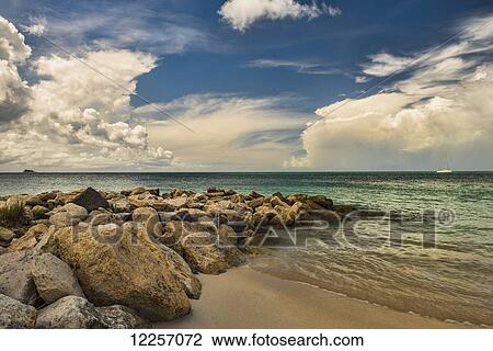 Stock Image - Cumulus clouds over Dickenson Bay; St. John's, Antigua, West Indies. Fotosearch