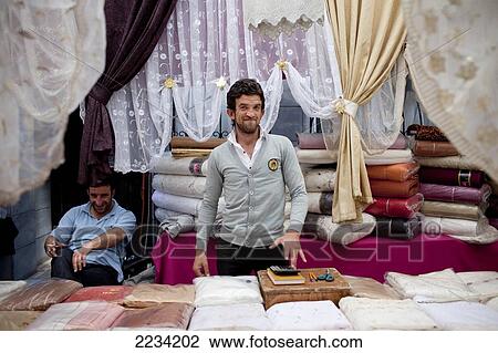Stock Image - Curtains vendor at Carsamba Pazari, the Wednesday Market in Fatih is one of Istanbul's oldest and most colourful market places, which is located around a network of streets surrounding the Fatih Mosque in Istanbul, Turkey. Photo. Fotosearch