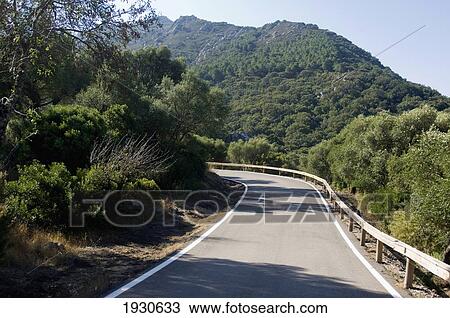 Stock Image - Curved Empty Road In Lush Mountains; France. Fotosearch