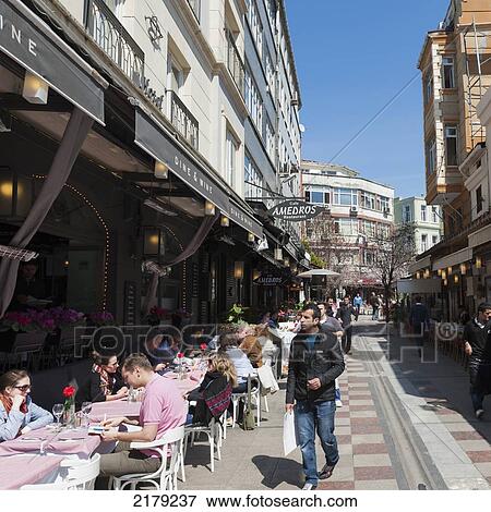 Customers Eating At An Outdoor Cafe And Pedestrians Walking Between Buildings; Istanbul Turkey View Large Photo Image Stock Photo - Customers Eating At An Outdoor Cafe And Pedestrians Walking Between Buildings; Istanbul Turkey. Fotosearch