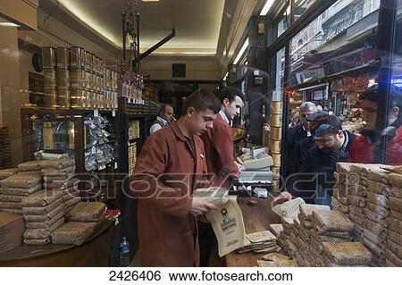 Stock Photograph - Customers lined up at a shop window as workers package their purchases; Istanbul, Turkey. Fotosearch