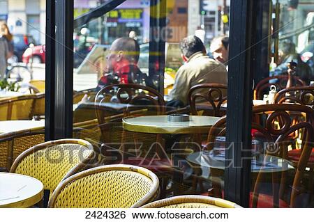 Customers of a restaurant sitting on an outdoor patio as viewed from the interior window; Paris, France View Large Photo Image Stock Photograph - Customers of a restaurant sitting on an outdoor patio as viewed from the interior window; Paris, France. Fotosearch
