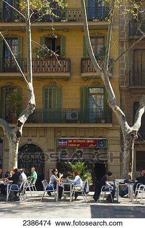 Picture - Customers sit at tables on an outdoor restaurant patio; Barcelona, Spain. Fotosearch