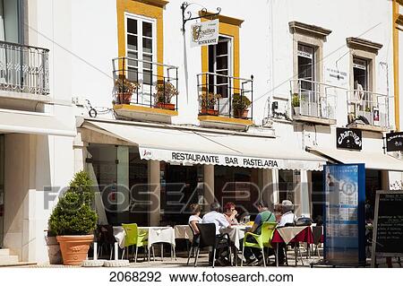 Stock Image - Customers Sitting On A Restaurant's Outdoor Patio; Faro Algarve Portugal. Fotosearch