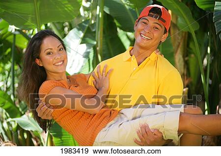 Cute Local Couple, Guy Cradling Girl In His Arms. View Large Photo Image Stock Photo - Cute Local Couple, Guy Cradling Girl In His Arms.. Fotosearch