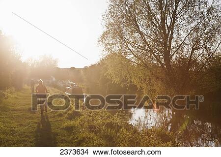 Cycling along Kennet and Avon Canal at sunset; Wiltshire, England View Large Photo Image Picture - Cycling along Kennet and Avon Canal at sunset; Wiltshire, England. Fotosearch