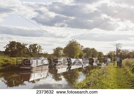 Stock Image - Cycling along path next to Kennet and Avon Canal; Great Bedwyn, Wiltshire, England. Fotosearch