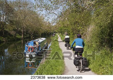 Stock Photo - Cycling along path next to Kennet and Avon Canal; Wiltshire, England. Fotosearch