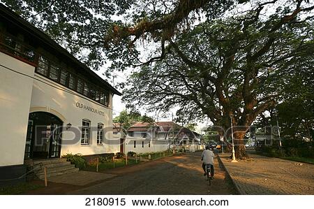 Stock Photography - Cycling down a street; Fort Kochi, Kerala, India. Fotosearch