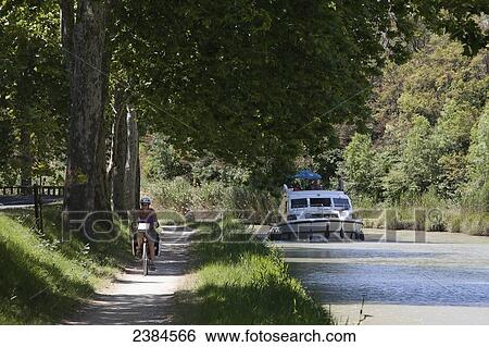 Cyclist cycling on banks of popular Canal du Midi; France View Large Photo Image Stock Photograph - Cyclist cycling on banks of popular Canal du Midi; France. Fotosearch