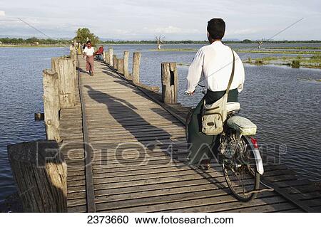 Cyclist goes across U Bein Bridge, made of Teak wood; Mandaly, Burma View Large Photo Image Stock Image - Cyclist goes across U Bein Bridge, made of Teak wood; Mandaly, Burma. Fotosearch