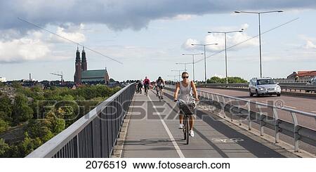 Cyclists On A Path Alongside A Road; Stockholm Sweden View Large Photo Image Stock Photo - Cyclists On A Path Alongside A Road; Stockholm Sweden. Fotosearch