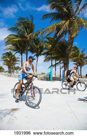 Stock Photograph - Cyclists On Promonade, Ocean Drive; South Beach, Miami, Florida, Usa.. Fotosearch