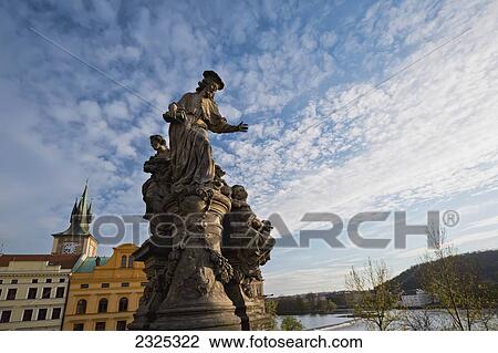 Stock Image - Czech Republic, Clock tower and buildings; Prague, Statue. Fotosearch